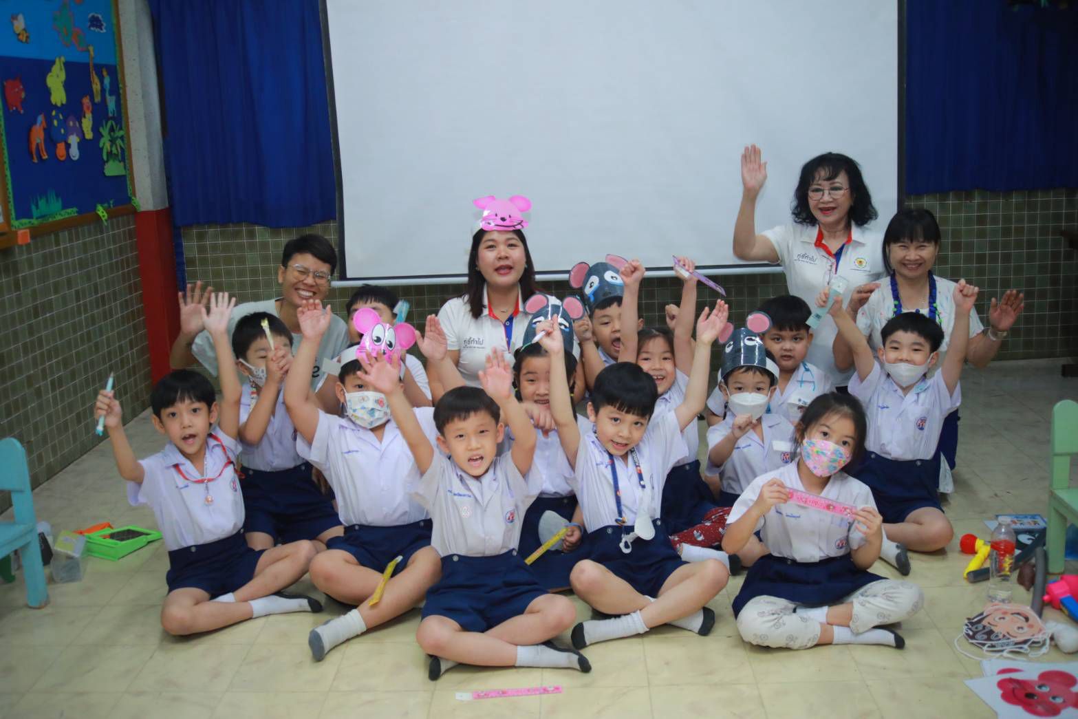 A joyful group photo of children and teachers with Jerry hats